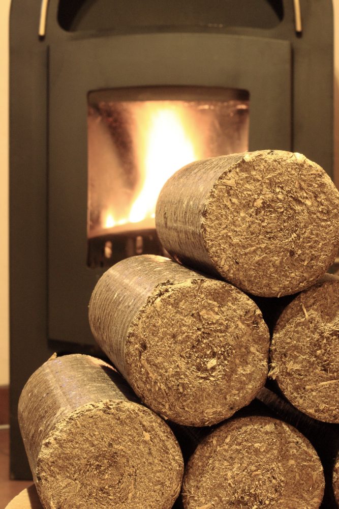 stack of briquettes in front of a woodburner. Heat logs woodfuel co-operative