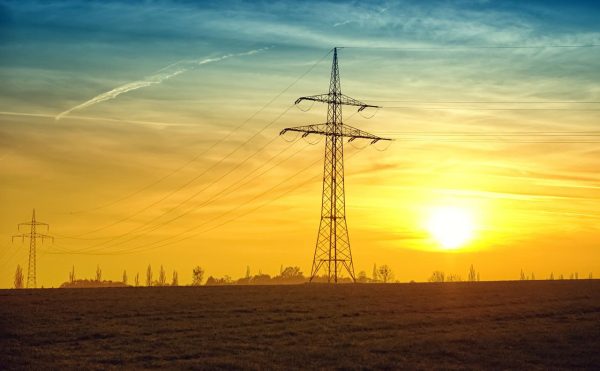 electiricty pylons against and orange sunset | Wood Fuel Coop